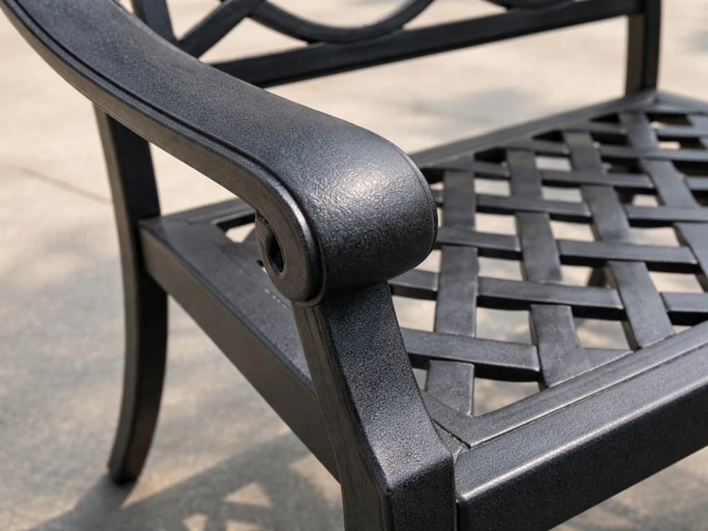 Close-up of a cast aluminum patio chair showing thick walls, weld edges, and anti-rust powder-coat sheen.