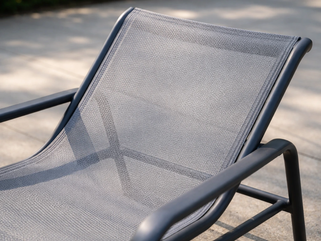 Close-up of breathable mesh sling fabric tightly stretched over a patio chair frame, no cushion.