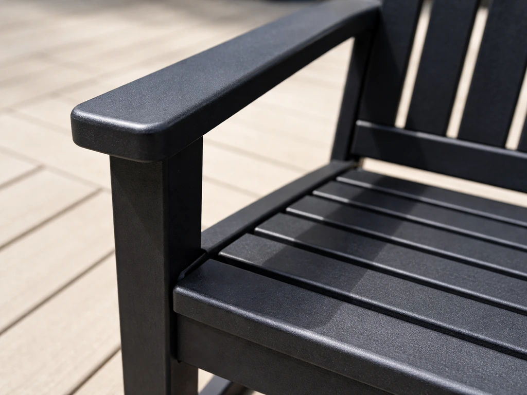 Close-up of molded HDPE/composite patio furniture armrest and slatted seat in natural sunlight.