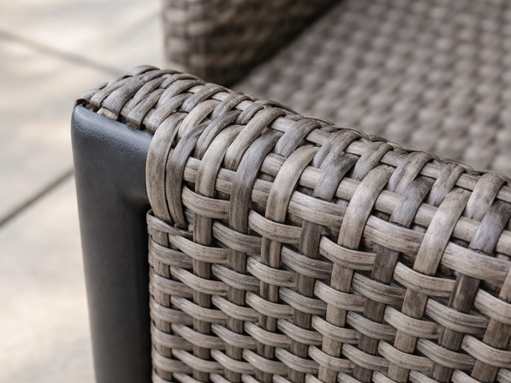 Close-up of synthetic PE polyrattan woven over a metal frame in an outdoor setting